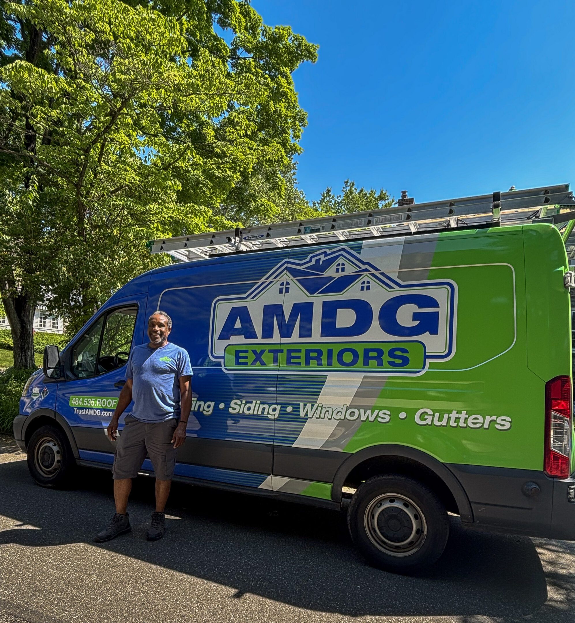 AMDG employee in front of AMDG van