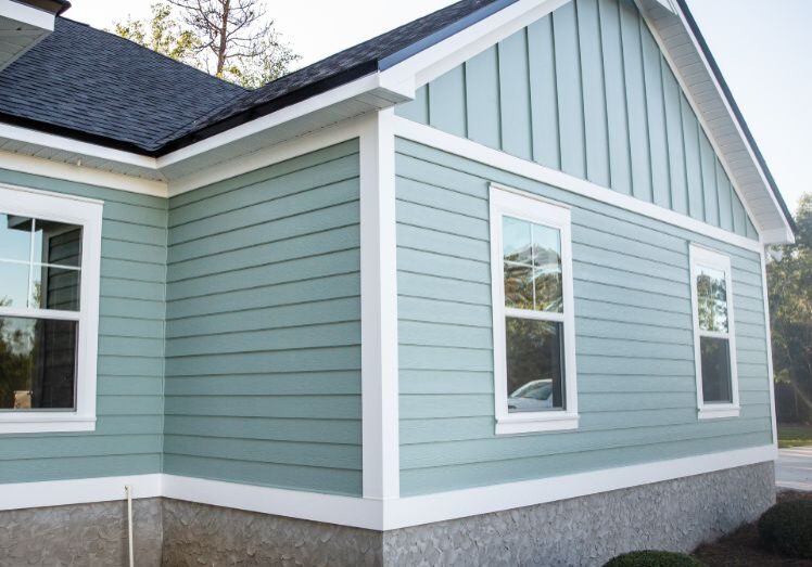 Light blue house exterior with white trim and small bushes.